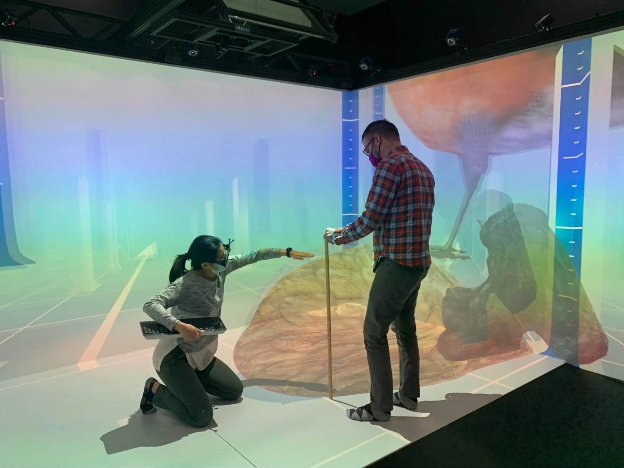 Professor demonstrating scale ruler in CAVE environment